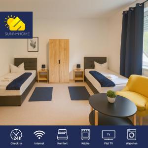 una habitación de hotel con dos camas y una mesa en SUNNYHOME Monteurwohnungen und Apartments in Bodenwöhr, en Bodenwöhr