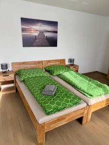 a bed with a green comforter in a room at Stadtquartier Völkermarkt in Völkermarkt