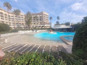 Chambres charmantes dans un appartement moderne à deux pas de la mer في كان: مسبح كبير امام مبنى كبير