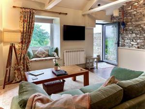 a living room with a couch and a table at The Owlery At Aysgarth in Aysgarth