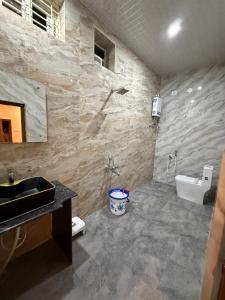 a bathroom with a sink and a toilet at shankar guest house in Hampi