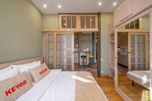 a bedroom with a large bed and a kitchen at Apartment KeyGo #0201 next to the National Gallery in Yerevan
