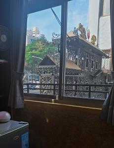 a window with a view of a building at 山露露品茶 6-25人 包層包棟民宿 in Tainan