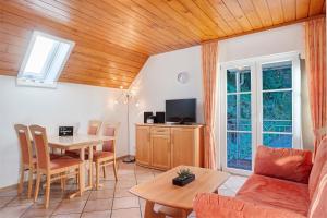 a living room with a table and a tv at Vogtadeshof in Wolfach