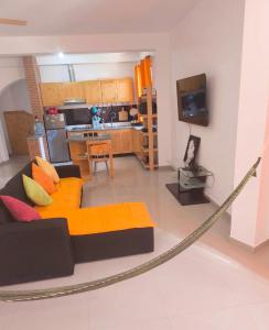 a living room with a couch and a kitchen at Casa Colibri - Confort et Authentique, à 300m de la plage ! in Mindelo