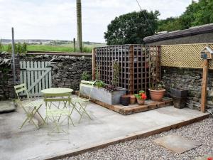 ホールトン・イン・リブルズデールにあるThree Peaks Houseの石壁のパティオ(テーブル、椅子付)