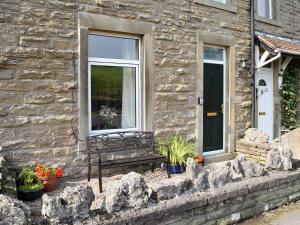 ホールトン・イン・リブルズデールにあるThree Peaks Houseの窓付きの石造りの建物前のベンチ