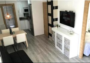 a living room with a television and a table and chairs at MODERNO NUEVO Luminoso WI-FI PLAZA DEL PILAR 2 in Zaragoza
