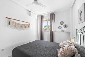 een witte slaapkamer met een bed en een raam bij Pleamar 23 in Torrevieja +16 foto's