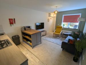 a kitchen and living room with a couch and a tv at Ruskin Apartment - Free Parking - 2 Bedrooms - Sleeps 3 in Midsomer Norton