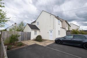 a black car parked in front of a white house at Ruskin Apartment - Free Parking - 2 Bedrooms - Sleeps 3 in Midsomer Norton