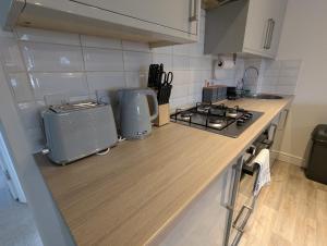 a kitchen with a stove and a counter top at Ruskin Apartment - Free Parking - 2 Bedrooms - Sleeps 3 in Midsomer Norton