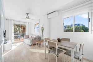 een witte woonkamer met een tafel en stoelen bij Pleamar 23 in Torrevieja