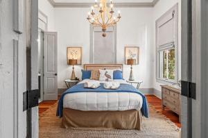 une chambre avec un lit et un lustre dans l'établissement The White Pelican Inn-Trolley a 5 Minute Walk Stops at SeawallBeach, à Galveston 41 autres photos