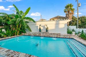 une piscine devant une maison dans l'établissement The White Pelican Inn-Trolley a 5 Minute Walk Stops at SeawallBeach, à Galveston