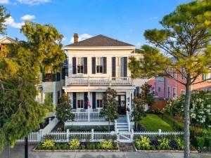 une grande maison blanche avec une clôture blanche dans l'établissement The White Pelican Inn-Trolley a 5 Minute Walk Stops at SeawallBeach, à Galveston