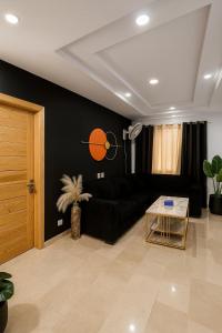 uma sala de estar com um sofá preto e uma mesa em Moonlight 1 Bed Apartment em Dargai