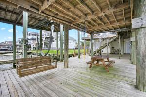 a wooden porch with a bench on a dock at Bayside Retreat Bring your boat private boat ramp at this fabulous bayfront home in League City