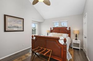 a bedroom with a wooden bed and a ceiling fan at Bayside Retreat Bring your boat private boat ramp at this fabulous bayfront home in League City +30 photos