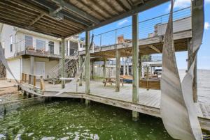 a dock with a house on the water at Bayside Retreat Bring your boat private boat ramp at this fabulous bayfront home in League City