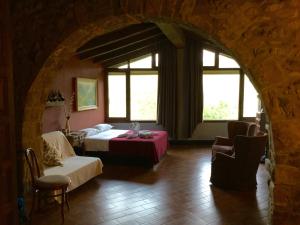 a bedroom with a bed and a room with windows at Mas Pardas in Santa Pau