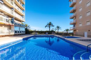 een zwembad voor een gebouw bij Pleamar 23 in Torrevieja