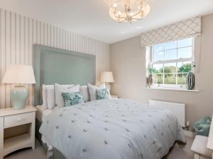 a bedroom with a large bed and a chandelier at Pass the Keys Former Show Home 6 min walk to Deddington in Deddington