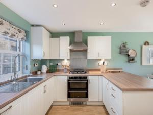 a kitchen with white cabinets and a sink at Pass the Keys Former Show Home 6 min walk to Deddington in Deddington +11 photos