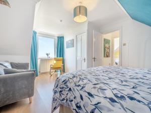 a bedroom with a bed and a couch and a chair at Aird Cottage in Dunure