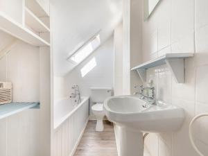 a white bathroom with a sink and a toilet at Aird Cottage in Dunure