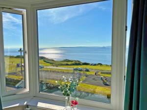 a window with a view of the ocean at Aird Cottage in Dunure