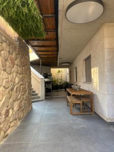 a room with a stone wall and a wooden table at Z Lotus Garden בריכה מחוממת in Eilat