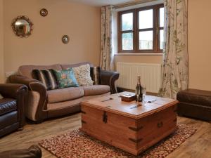 a living room with a couch and a coffee table at The Old Forge in Burshill