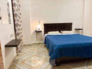 ein Schlafzimmer mit einem Bett mit einer blauen Bettdecke in der Unterkunft SR Homes - Your Gateway to Hyderabad in Hyderabad