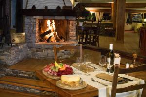a table in a restaurant with a fireplace at Hotel La Prairie in Crans-Montana
