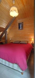 ein Schlafzimmer mit einem großen Bett in einem Holzzimmer in der Unterkunft Le Frenola in Saint-Pierre-dʼEntremont