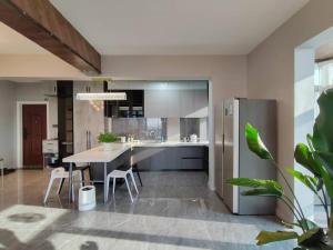 Una cocina con una mesa y un refrigerador de acero inoxidable. en Central Avenue Luxury River View Apartment, en Harbin