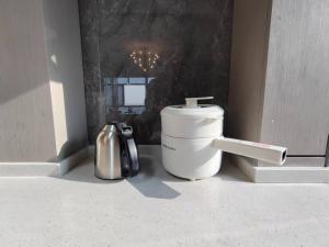 Una encimera de cocina con una cafetera y un fregadero. en Central Avenue Luxury River View Apartment, en Harbin 30 fotos más