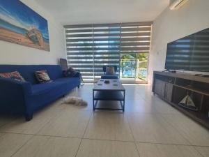 un salon avec un canapé bleu et une table dans l'établissement Playa Blanca Beach and Lagoon Residences, à Cruce del Farallón