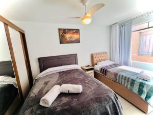 een slaapkamer met 2 bedden en handdoeken bij Apartamento Central com 4 Quartos in Ponta Grossa