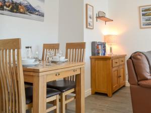 ein Esszimmer mit Tisch und Stühlen und einer Couch in der Unterkunft Wise Cottage in Keswick
