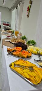 Un buffet con frutas y verduras en una mesa. en Pousada Apatej, en Peruíbe