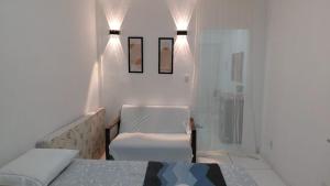 a bedroom with a bed and a chair and a shower at Vista da praça Castro Alves in Salvador