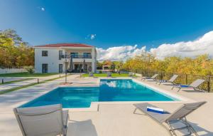een zwembad met stoelen en een huis bij Villa Lea-Makarska by Villas Guide in Grubine