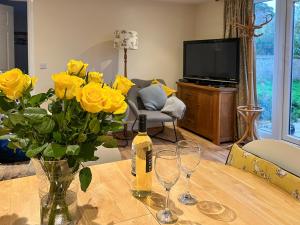 ScagglethorpeにあるDelamere House- The Snugのワイン1本と黄色いバラのテーブル