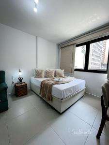 a bedroom with a bed with white walls and windows at Skylux 405 e 603 in Rio de Janeiro