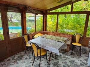 a dining room with a table and chairs and a view of the water at Guest House Valchanovi in Elkhovo