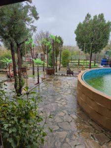 a garden with a swimming pool and trees and a fence at Guest House Valchanovi in Elkhovo