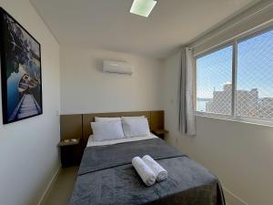 メイア・プライアにあるApto a 750m do Mar c/ varanda e churrasq. GVT2105のベッドとタオル2枚のある寝室