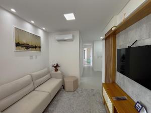 メイア・プライアにあるApto a 750m do Mar c/ varanda e churrasq. GVT2105のソファと薄型テレビのあるリビングルーム
